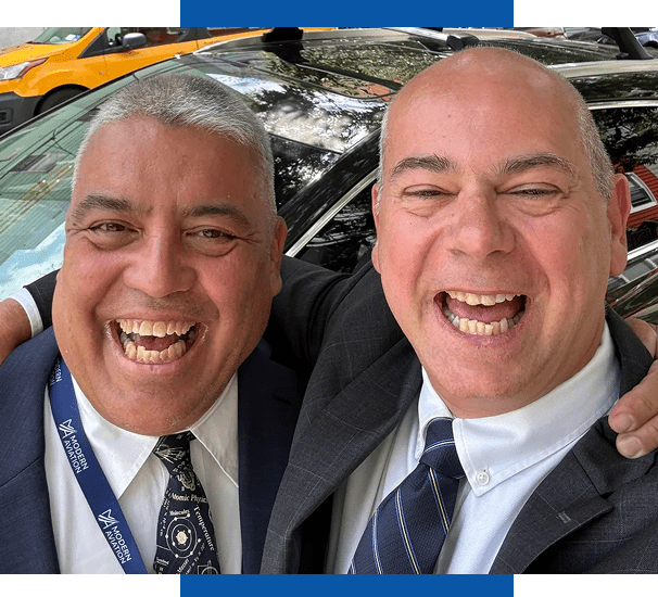 Two men in suits smiling for selfie
