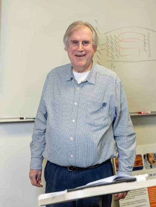 Man smiling in front of whiteboard